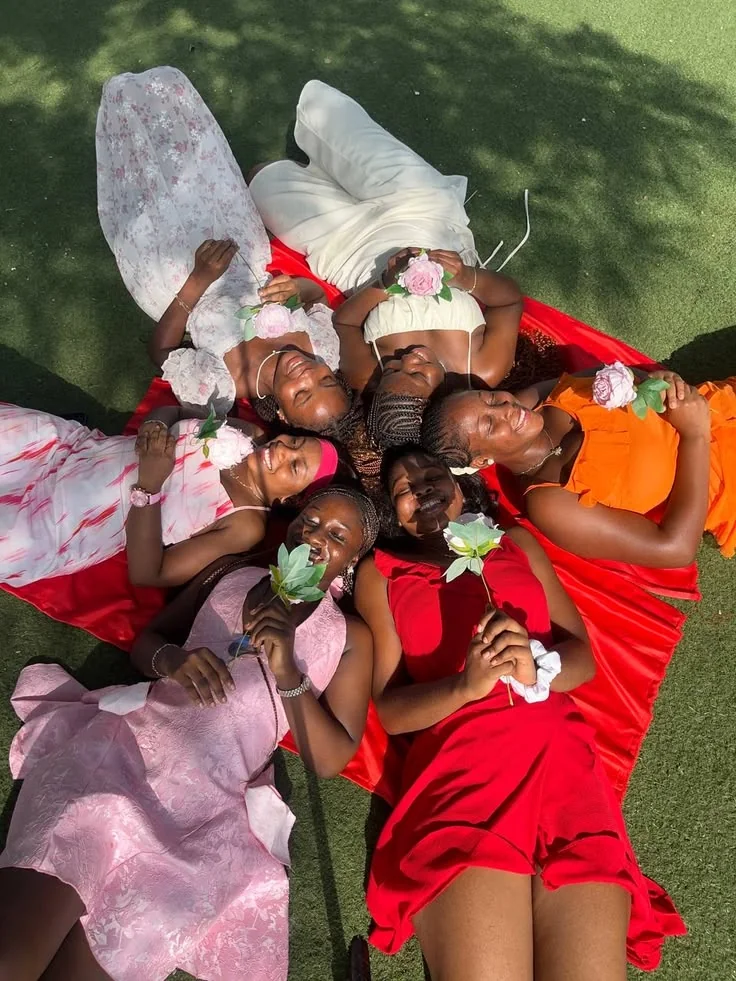 Friends enjoying a sunny picnic in a lush green park, relaxing on blankets with baskets of food